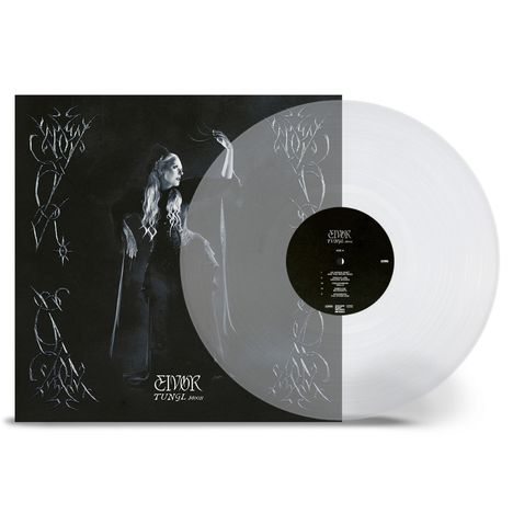 Text: EIVØR TUNGL MOON. Graue Vinyl-Schallplatte, schwarzes Cover mit Frau in dunkler Kleidung.