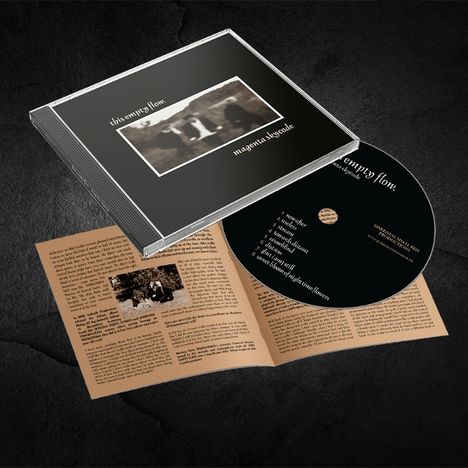 CD-Album mit schwarzem Cover "this empty flow. magenta skycode", CD und Textheft auf braunem Papier.