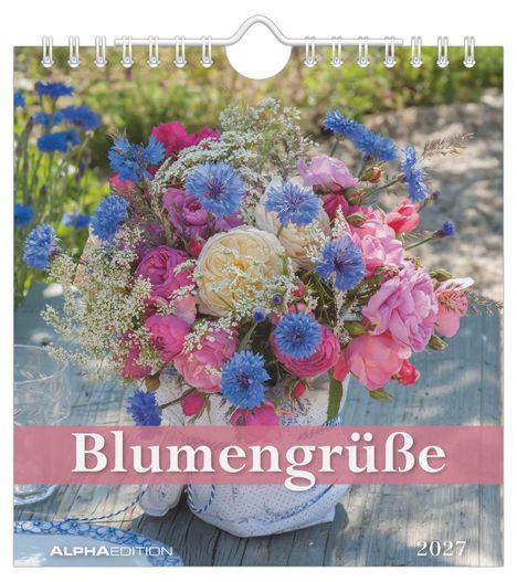 "Blumengrüße 2027." Ein bunter Blumenstrauß mit blauen und rosa Blüten in einer Vase auf einem Holztisch.
