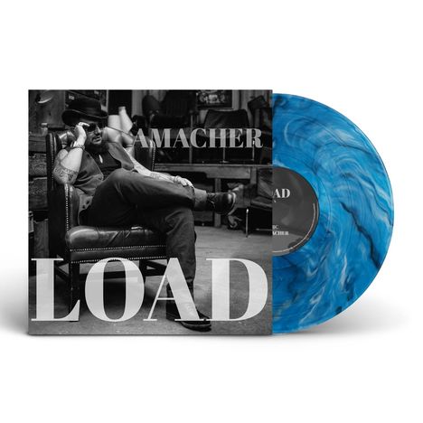 „AMACHER LOAD“: Ein Mann im Sessel, lässig gekleidet und mit Hut. Die Schallplatte ist blau marmoriert.