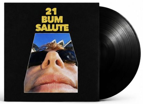 „21 BUM SALUTE“ in gelber Schrift. Darunter ein Nahaufnahme eines Gesichts mit Sonnenbrille, Vinylplatte sichtbar.