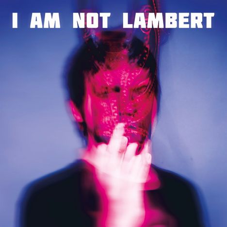 Text: "I AM NOT LAMBERT", verschwommenes Gesicht in Rot mit Maske, verschwommene Hand hebt die Maske leicht an.