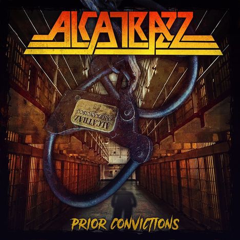 „ALCATRAZZ“ in orange-gelber Schrift. „Prior Convictions“ unten. Abbildung eines Gefängniskorridors mit Kette.