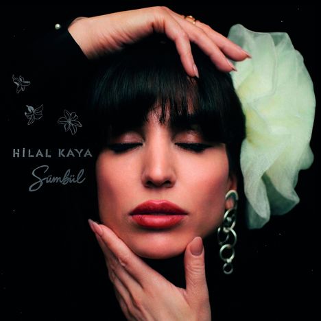 Text: "HİLAL KAYA", "Sümbül". Frau mit geschlossenen Augen, Hand am Kopf und Kinn, großer Ohrring, helle Blume im Haar.