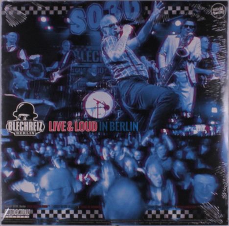 Blechschild, "BLECHREIZ BERLIN", "LIVE & LOUD IN BERLIN", Bühne, Band, energetischer Sänger, Saxophonist, blaue Lichtstimmung.