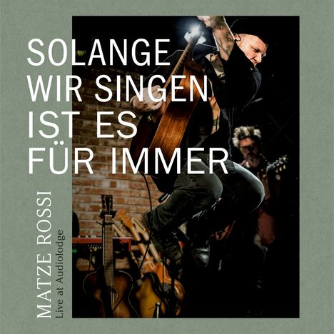 Texte: "Solange wir singen ist es für immer", "Matze Rossi Live at Audiolodge". Ein Musiker springt mit Gitarre in einer dynamischen Pose.