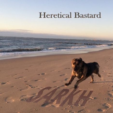 "Heretical Bastard" oben; "SARKH" im Sand. Ein Hund läuft am Strand entlang, Meer im Hintergrund.