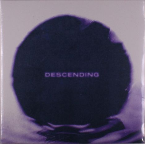 Text "DESCENDING" in der Mitte, lila Kreis auf hellgrauem Hintergrund, unscharf.