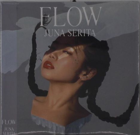 Text: "FLOW JUNA SERITA". Eine Frau mit roten Lippen und zwei geflochtenen Zöpfen blickt nach oben.