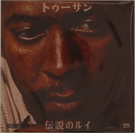 Japanische Schriftzeichen oben und unten. Nahaufnahme eines nachdenklichen Gesichts mit dunkler Haut und tiefem Blick.