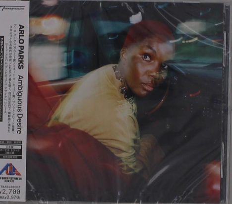 ARLO PARKS, Ambiguous Desire. Person im Auto, seitlich und nach hinten schauend, in bunter Lichtstimmung.