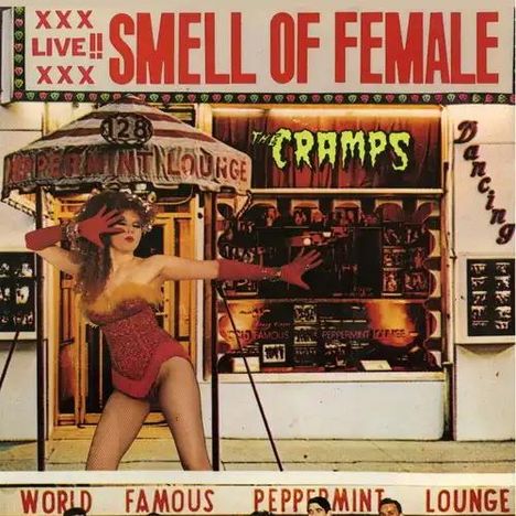 "XXX Live!! Smell of Female. The Cramps. World Famous Peppermint Lounge. Frau in rotem Outfit posiert davor."