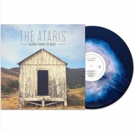 „THE ATARIS - SILVER TURNS TO RUST“. Es zeigt eine kleine Holzhütte vor hügeliger Landschaft, daneben eine Vinyl-Schallplatte.