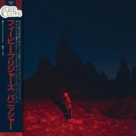 Links steht vertikaler japanischer Text. Im Hintergrund sind dunkle Felsen und ein Nachthimmel mit einem Skelett im Vordergrund.