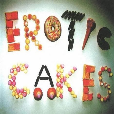 "EROTIC CAKES" in Buchstaben aus Gebäck und Süßigkeiten geformt. Lebhaft und bunt arrangiert.