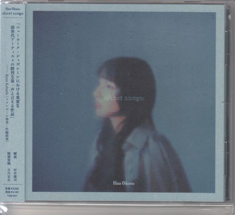 „short songs“, „Hina Oikawa“. Verschwommene Frau mit dunklem Haar in Mantel vor blauem Hintergrund.