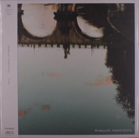 "Hideyuki Hashimoto, Time" steht links vertikal und unten horizontal. Oben ist eine Brücke, die sich im Wasser spiegelt.
