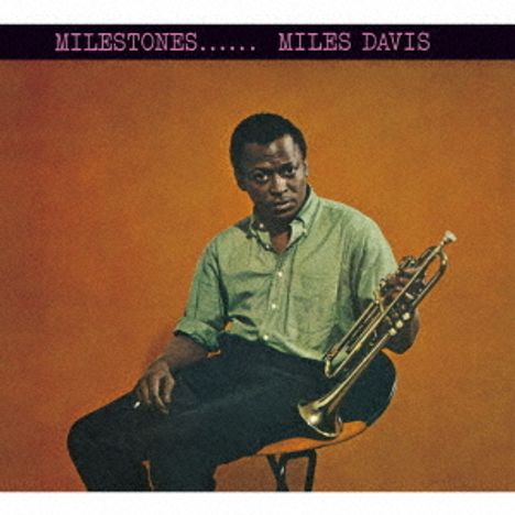 Text oben: "MILESTONES...... MILES DAVIS". Ein Mann sitzt mit einer Trompete vor einem orange-braunen Hintergrund.