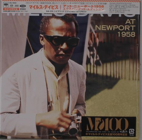 "At Newport 1958" und japanische Schriftzeichen. Ein Mann mit Sonnenbrille hält eine Kamera, steht vor einem Zelt.