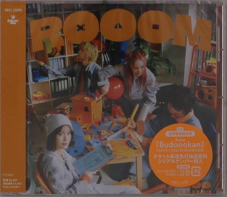 "ROOOM" in großen Buchstaben, darunter eine lebhafte Szene mit vier Personen, die an einem Tisch voller bunter Objekte sitzen.