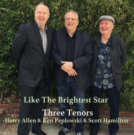 "Like The Brightest Star Three Tenors Harry Allen & Ken Peplowski & Scott Hamilton." Drei lächelnde Männer vor grünen Pflanzen.