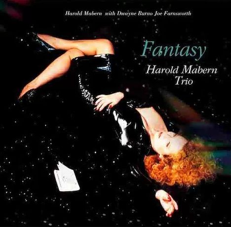 „Fantasy“, Harold Mabern Trio. Frau in schwarzem Outfit liegt auf schwarzem Hintergrund mit Sterneneffekt.
