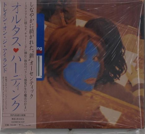 Japanischer Text und ein blau gefärbtes Gesicht auf einem verschwommenen Hintergrund.