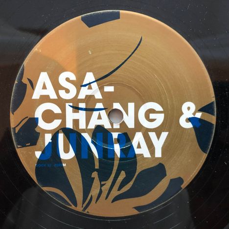 Text: "ASA-CHANG & JUNRAY". 
Design: Kreisförmige Scheibe mit blau-schwarzem floralen Muster auf goldbraunem Hintergrund.