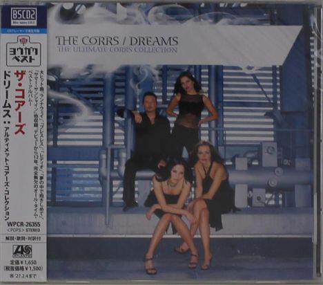 "The Corrs / Dreams: The Ultimate Corrs Collection"; zeigt vier Personen in eleganter Kleidung vor einer industriellen Kulisse.