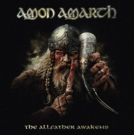 "Amon Amarth. The Allfather Awakens." Ein Krieger mit Helm hält ein Trinkhorn und ein Messer, blutverschmiert und wild.