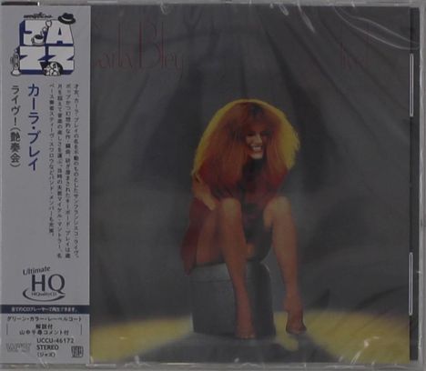 Text: "Carla Bley". Japanische Schriftzeichen links. Illustration: Lächelnde Frau mit rotem Haar sitzt auf einem Hocker.