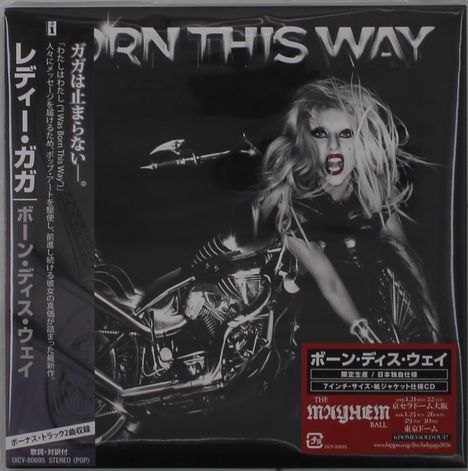 "Born This Way" in großen Buchstaben oben; Frau mit wildem Haar und aggressivem Gesicht auf einem Motorrad.