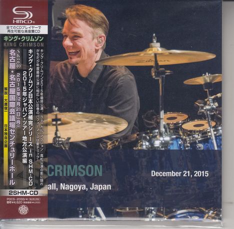 "King Crimson, Aichi Prefectural Arts Center, Nagoya, Japan, December 21, 2015." Drummer lächelt hinter Schlagzeug.