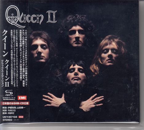 „Queen II“ steht oben in stilisierter Schrift. Vier Personen in schwarzer Kleidung vor dunklem Hintergrund.