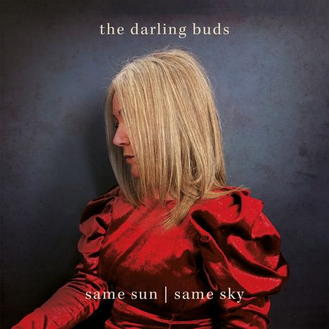 "the darling buds", "same sun | same sky", Frau mit blonden Haaren im Profil in rotem Kleid auf blauem Hintergrund.