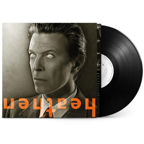Text: "heathen" in orange, um 180 Grad gedreht. Ein Mensch mit starren, hellen Augen und Anzug. Sepia-Ton.