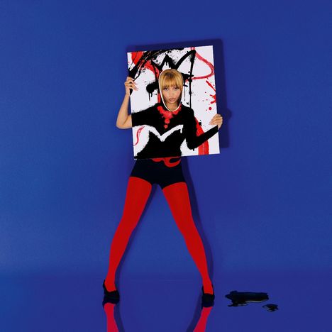 Ein Gemälde, das eine Frau mit blonden Haaren zeigt. Sie hält ein gemustertes Bild, trägt rote Strumpfhosen vor blauem Hintergrund.