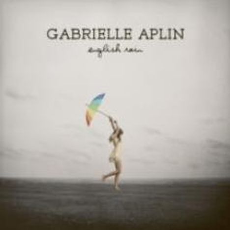 "GABRIELLE APLIN", "English rain". Person springt mit buntem Regenschirm auf dunklem Boden, grauer Himmel im Hintergrund.