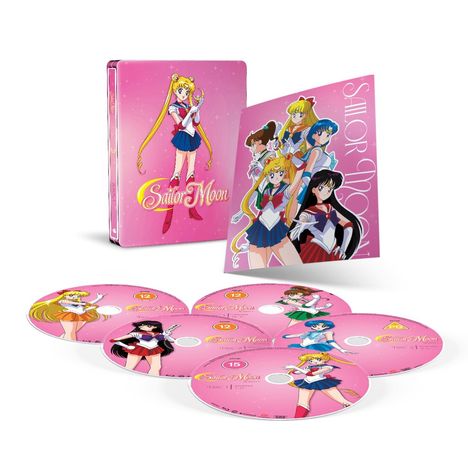 „Sailor Moon“ – Pinke Box mit Figur Sailor Moon; daneben Poster und mehrere pinke DVDs mit verschiedenen Charakteren.