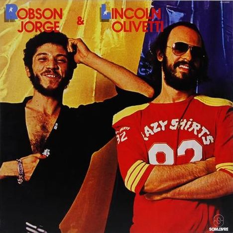 "Robson Jorge & Lincoln Olivetti" oben. Zwei Männer, einer im Anzug, einer im roten Shirt mit Aufdruck "Crazy Shirts 82".