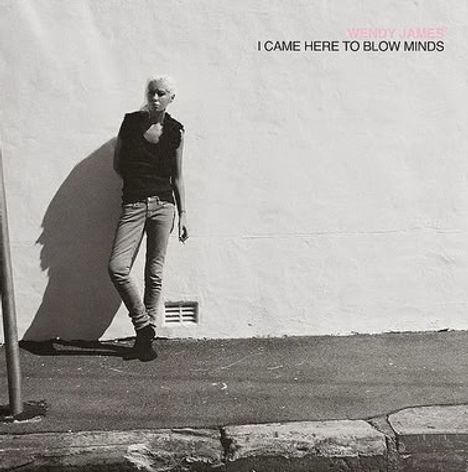 Text: "Wendy James, I Came Here to Blow Minds". Eine Person lehnt an einer weißen Wand, beleuchtet von der Sonne.