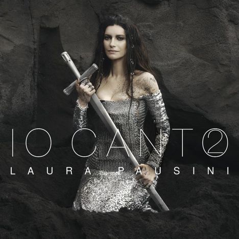 Texte: "Io Canto", "Laura Pausini". Eine Frau in einem glänzenden Kleid hält ein Schwert, umgeben von dunkler Erde.