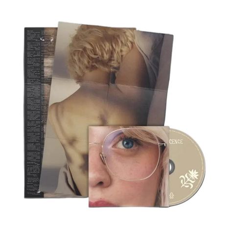 Das Bild zeigt ein CD-Cover mit dem Wort "SILENCE". Ein Poster mit einem Rücken-Foto und ein Foto eines Gesichts sind sichtbar.