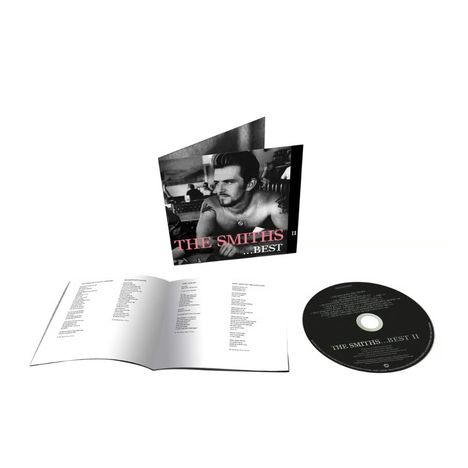 "The Smiths ...Best II" steht in rosa und weißem Text. Es zeigt einen Mann mit Tattoos, der an einem Tisch sitzt.