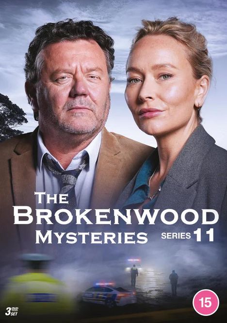 "The Brokenwood Mysteries Series 11" steht mit zwei Personen im Vordergrund. Im Hintergrund Polizeiautos im Nebel.
