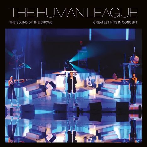 Oben steht „THE HUMAN LEAGUE“. Darunter sind Menschen auf einer beleuchteten Bühne, Instrumente sind sichtbar.