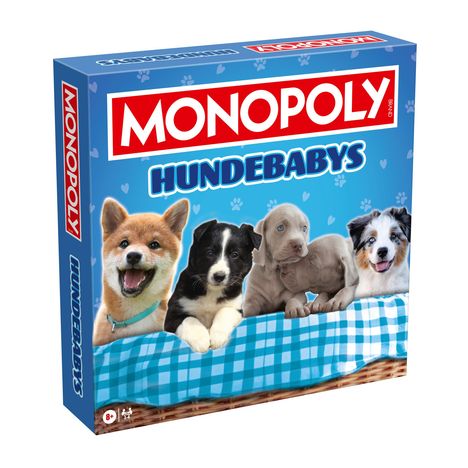 "MONOPOLY HUNDEBABYS" steht auf einer Schachtel, die Hundewelpen auf einer karierten Decke zeigt.