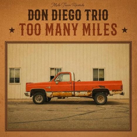 "Don Diego Trio Too Many Miles" in großer Schrift, daneben ein altes, rostiges rotes Pickup-Truck vor einer Wand.