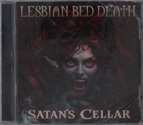Oben steht "Lesbian Bed Death", unten "Satan's Cellar". Eine Illustration zeigt ein dämonisches Gesicht mit glühenden Augen.