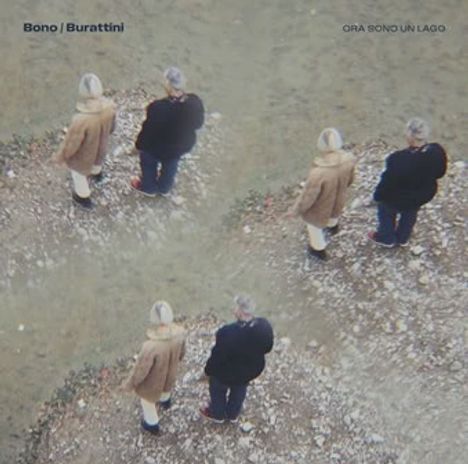 „Bono / Burattini“ und „Ora sono un lago“. Zwei Personen stehen auf einem steinigen Untergrund, mehrfach gespiegelt.